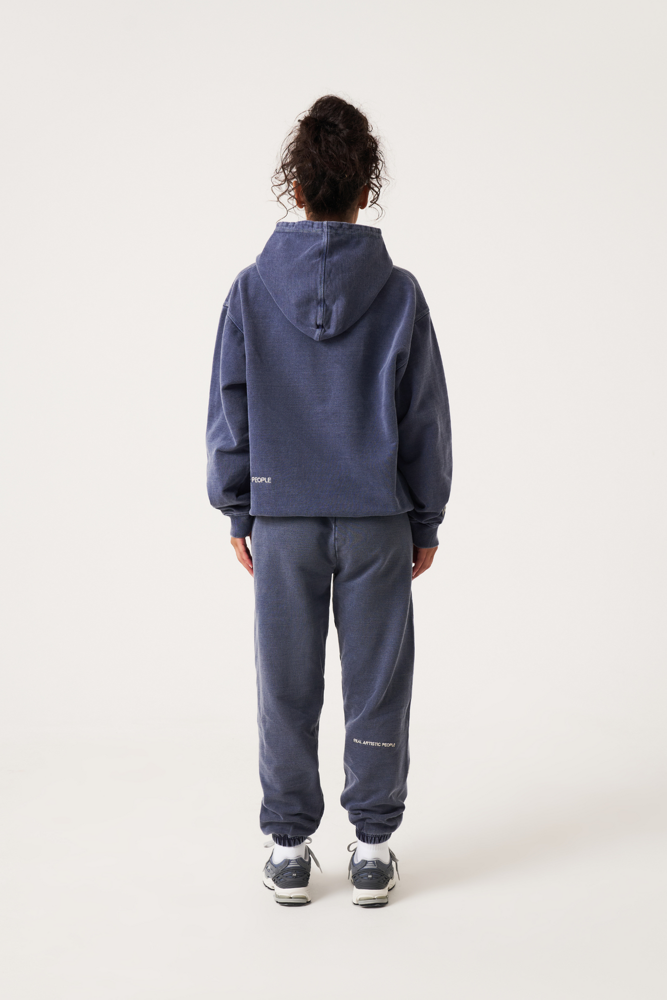 vrouw in trendy en comfortabele oversized paarse trui met capuchon en de tekst "for the culture" op de borst