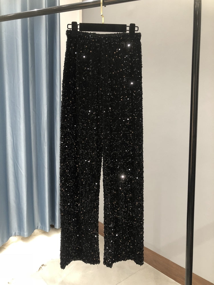 Sienna glitter wijde-pijpen broek: sprankelende glamour en comfort in één. Perfect voor feestdagen, diners of evenementen waar je wilt schitteren. Met een luxueus paillettenontwerp, wijde pijpen voor een chique silhouet en een comfortabele tailleband is deze broek ideaal om een stijlvol statement te maken. Verkrijgbaar in Zilver, Zwart en Zwart/Zilver, in één maat. Bestel nu en geef je garderobe een moderne, elegante touch!
