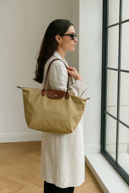 Vrouw met beige nylon tas Noa met leren details en gouden knoopjes. de tas is waterdicht en ruim 