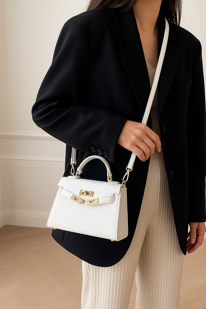 Elegante schoudertas voor dames met goudkleurige details, top handle en verstelbare schouderriem, gestyled voor zowel casual als zakelijke outfits.