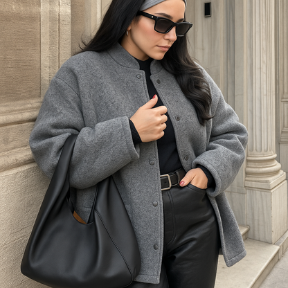 Vrouw draagt een oversized grijs wollen bomberjack met drukknopen