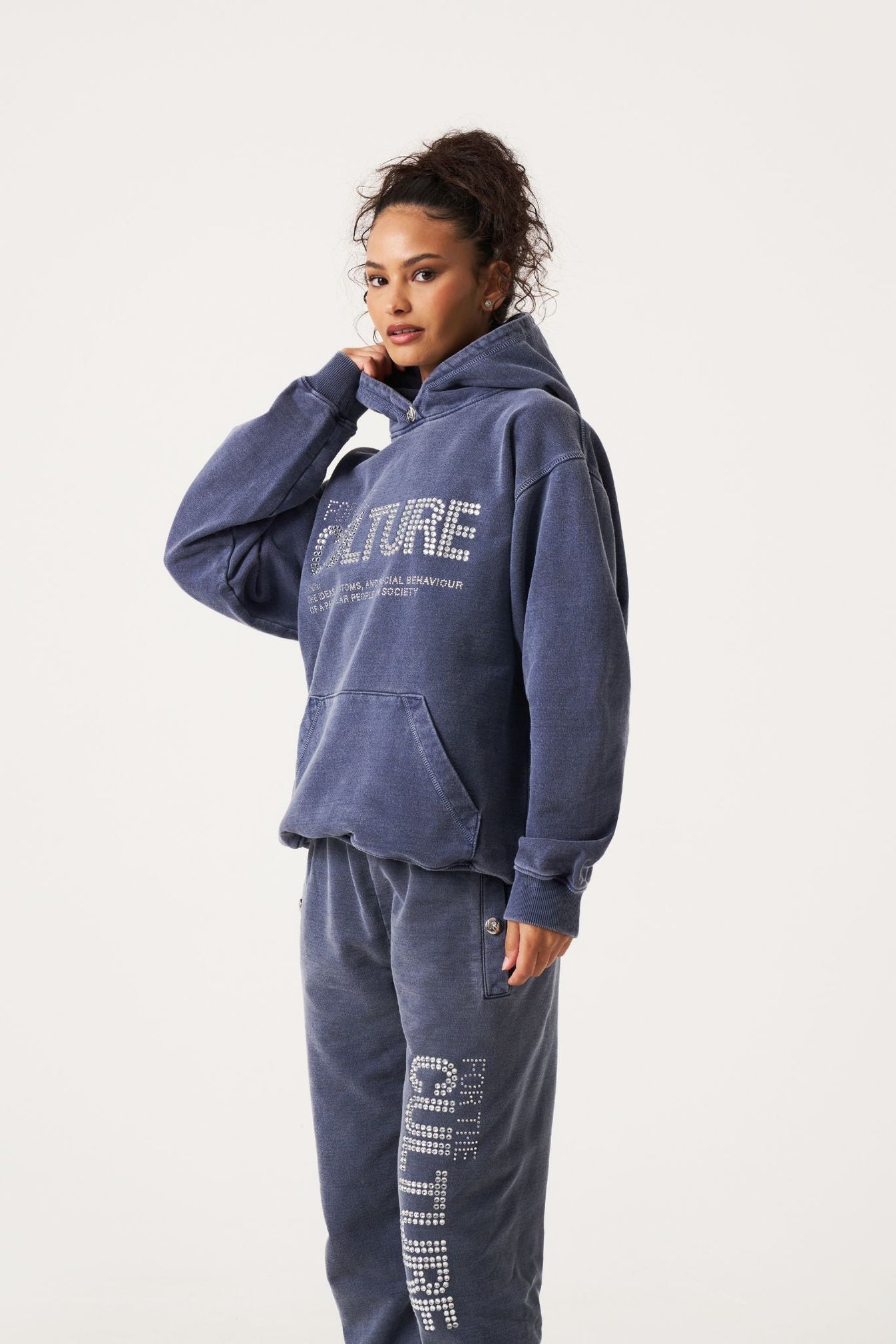 vrouw in trendy en comfortabele oversized paarse trui met capuchon en de tekst "for the culture" op de borst 