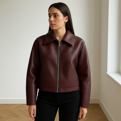 Bordeauxrode oversized damesjas van kunstleer met zilverkleurige rits, gedragen door vrouw in COS/Zara setting, stijlvolle herfst- of winterjas met moderne pasvorm.