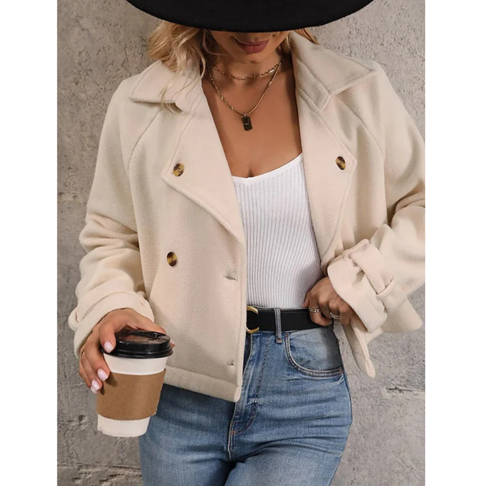 vrouw stijlvolle korte beige mantel jas van zachte stof met knoopsluiting en reverskraag