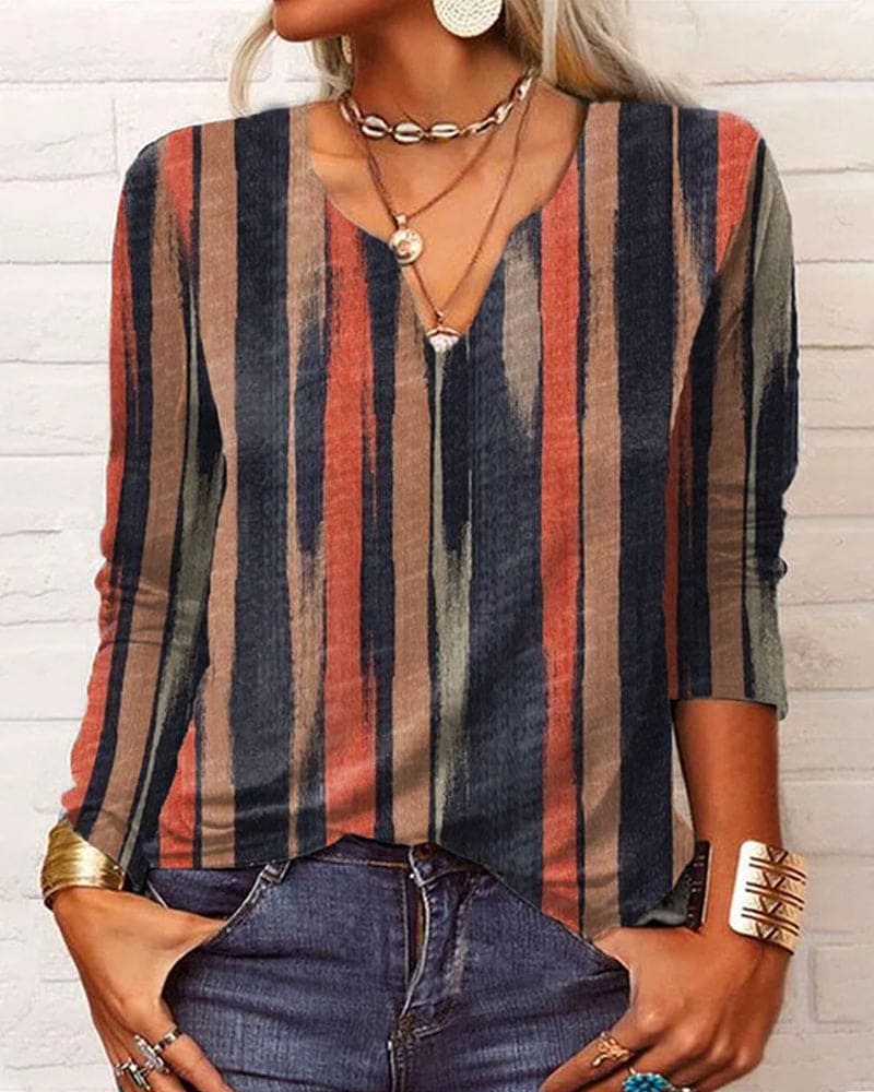 vrouw in bedrukte top met verschillende patronen en kleuren en lange mouwen