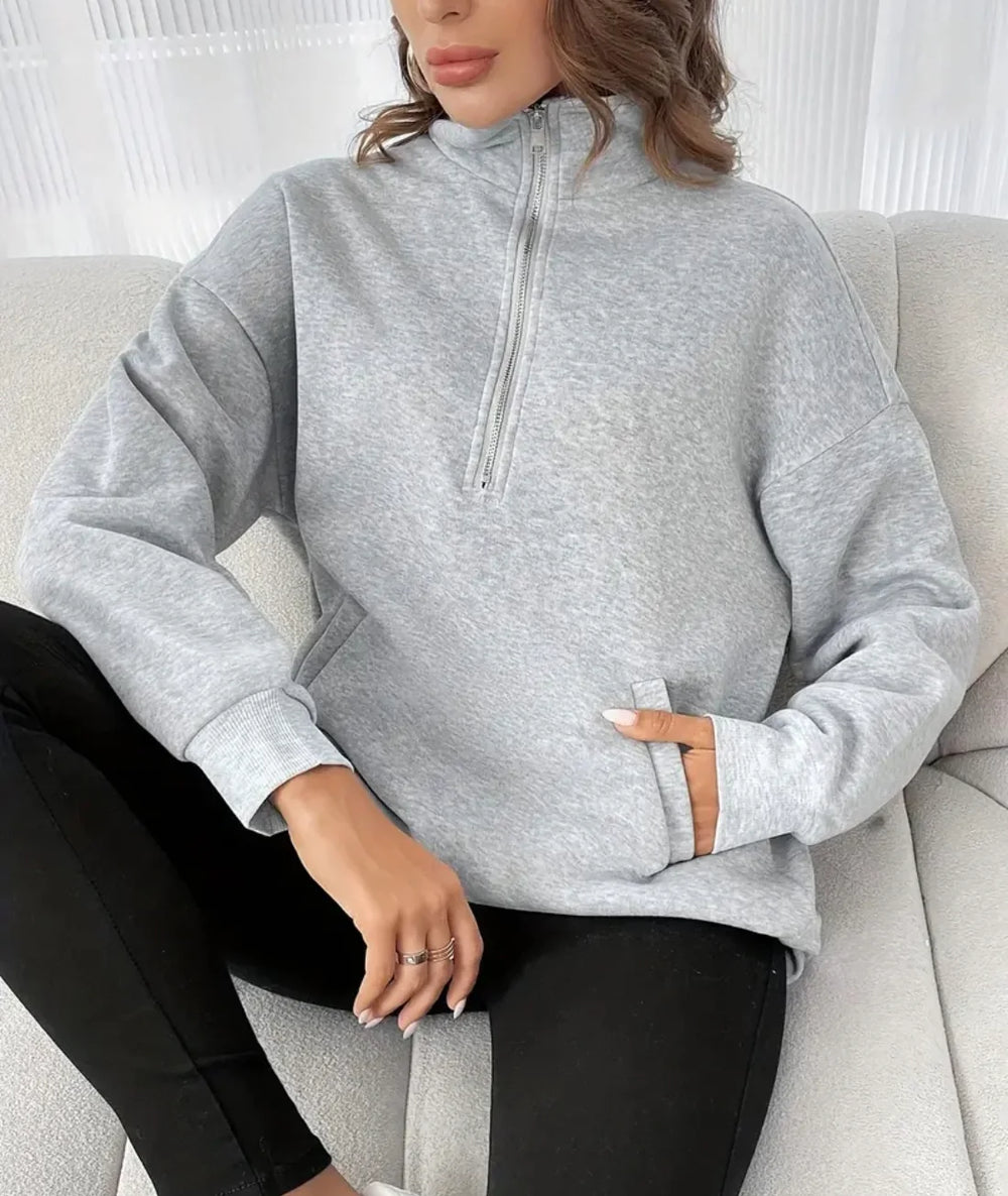 Tallulah sweatshirt: stijlvolle half-zip trui voor comfort en casual elegantie. Perfect voor knusse avonden, casual uitjes en ontspannen dagen thuis. Ontspannen pasvorm en ideaal voor laagjes, met een veelzijdige grijze kleur die bij elke outfit past. Gemaakt voor ultiem comfort en een chique, moeiteloze look. Verkrijgbaar in maten S-2XL. Upgrade je garderobe met de Tallulah en geniet van een mix van stijl en functionaliteit. Bestel nu en ervaar de perfecte combinatie van warmte en verfijning!