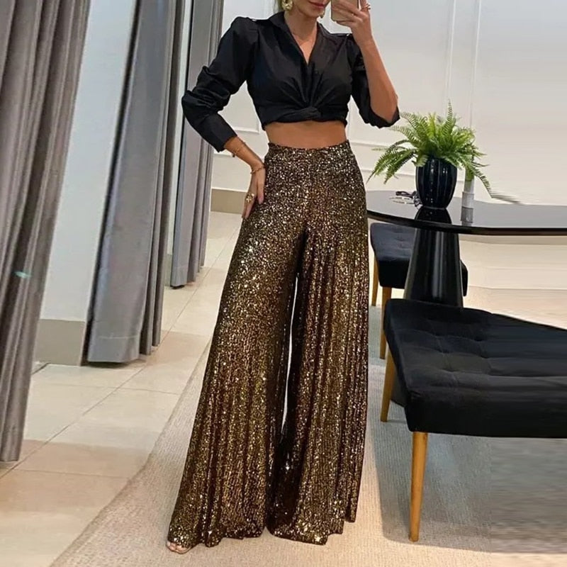 Rosalinde wide-leg broek: stijlvolle broek met schitterend paillettenontwerp, high-waisted pasvorm en vloeiend silhouet. Perfect voor avondfeesten, evenementen en feestelijke gelegenheden. Verkrijgbaar in Donkerbruin, Zwart en Zilver, in maten S t/m 5XL. Combineer glamour en comfort met de Rosalinde en laat je outfit stralen. Bestel nu en voeg een vleugje sprankeling toe aan je avondgarderobe!
