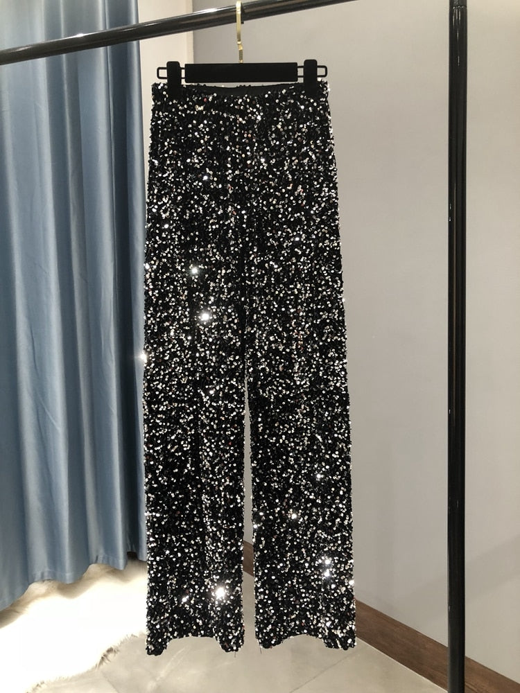 Sienna glitter wijde-pijpen broek: sprankelende glamour en comfort in één. Perfect voor feestdagen, diners of evenementen waar je wilt schitteren. Met een luxueus paillettenontwerp, wijde pijpen voor een chique silhouet en een comfortabele tailleband is deze broek ideaal om een stijlvol statement te maken. Verkrijgbaar in Zilver, Zwart en Zwart/Zilver, in één maat. Bestel nu en geef je garderobe een moderne, elegante touch!